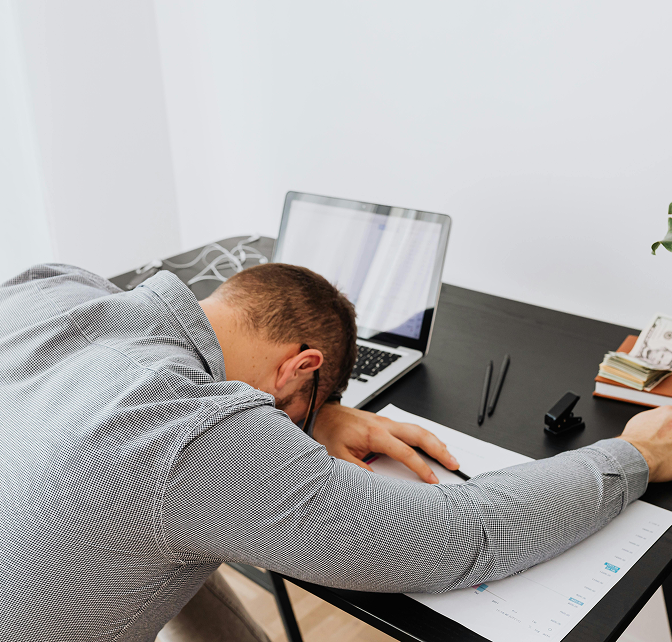Man sleeping at his desk at work.