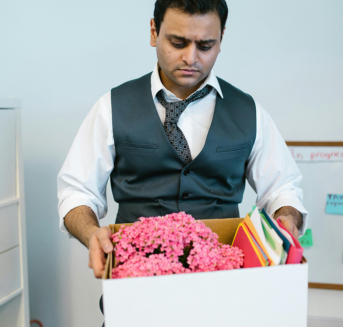 Person holding a box full of their stuff from work